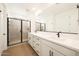 Modern bathroom with double vanity, black fixtures, tiled shower, and wood-look flooring at 17250 W Via Dona Rd, Surprise, AZ 85387