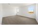 Bright bedroom featuring neutral carpet, white walls, and two sunlit windows with scenic views at 17250 W Via Dona Rd, Surprise, AZ 85387