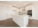 Modern kitchen featuring a large island, white cabinetry, and stainless steel appliances at 17250 W Via Dona Rd, Surprise, AZ 85387