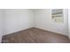 Modern bedroom featuring wood-look floors and a bright window for natural light at 17429 W Via Dona Rd, Surprise, AZ 85387