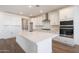 Modern kitchen boasts stainless steel appliances, white cabinets, a spacious island, and stylish backsplash at 17429 W Via Dona Rd, Surprise, AZ 85387