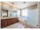 Bright bathroom with double vanity, glass shower, soaking tub and ceramic tile flooring at 17981 W Agave Rd, Goodyear, AZ 85338