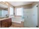 Well-lit bathroom featuring a bathtub, frosted-glass shower, vanity, and ceramic tile flooring at 17981 W Agave Rd, Goodyear, AZ 85338