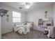 Bright bedroom features a ceiling fan, cozy bed, workstation, and neutral-colored walls at 17981 W Agave Rd, Goodyear, AZ 85338