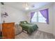 Bright bedroom with ceiling fan, and natural light through window with purple curtains at 17981 W Agave Rd, Goodyear, AZ 85338