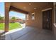 View of a covered patio that opens up to the backyard featuring green grass and outdoor seating at 17981 W Agave Rd, Goodyear, AZ 85338