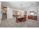 Bright dining room featuring a wood table, six chairs, and a modern chandelier at 17981 W Agave Rd, Goodyear, AZ 85338