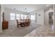 Bright dining room with a large wood table, carpet flooring, and plenty of natural light at 17981 W Agave Rd, Goodyear, AZ 85338