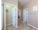 Hallway with doorways leading to various rooms, ceramic tile flooring, and neutral-colored walls at 17981 W Agave Rd, Goodyear, AZ 85338