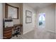Hallway with carpet, featuring built-in desk area and view of bedroom with purple curtains at 17981 W Agave Rd, Goodyear, AZ 85338