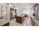Open-concept kitchen with stainless steel refrigerator, kitchen island, and dining area at 17981 W Agave Rd, Goodyear, AZ 85338