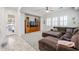 Living room with modern cabinet and brown sectional sofa, tile floor at 17981 W Agave Rd, Goodyear, AZ 85338