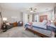 Inviting main bedroom featuring a seating area, ceiling fan, carpet, and a cozy bed at 17981 W Agave Rd, Goodyear, AZ 85338