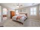 Comfortable main bedroom featuring a ceiling fan, natural light, and an arched entryway to the ensuite bathroom at 17981 W Agave Rd, Goodyear, AZ 85338