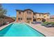 Inviting backyard with a turquoise pool, patio with seating, and well-maintained lawn at 17981 W Agave Rd, Goodyear, AZ 85338