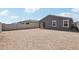 Backyard showcasing a dirt landscape, block fencing and the home's gray exterior with a patio at 18256 W La Senda Dr, Surprise, AZ 85387