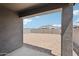 View from the covered patio of the backyard with dirt, block walls and a clear blue sky at 18256 W La Senda Dr, Surprise, AZ 85387