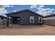 View of the home's rear exterior with a covered patio and spacious dirt backyard at 18256 W La Senda Dr, Surprise, AZ 85387