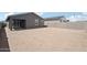 Backyard showcasing a dirt landscape, block fencing and the home's gray exterior with a patio at 18256 W La Senda Dr, Surprise, AZ 85387