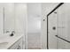 Bathroom featuring double sinks, dark hardware, and a walk-in shower with a glass door at 18256 W La Senda Dr, Surprise, AZ 85387