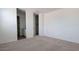 Spacious bedroom with neutral carpet and access to an en-suite bathroom and walk-in closet at 18256 W La Senda Dr, Surprise, AZ 85387