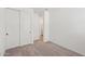 A bright bedroom with carpeted floors, a double door closet and a door leading to the bathroom at 18256 W La Senda Dr, Surprise, AZ 85387