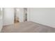 Spacious carpeted bedroom with white walls, a bathroom entrance, and a walk-in closet at 18256 W La Senda Dr, Surprise, AZ 85387
