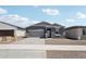Inviting single-Gathering home with a two-car garage, gray stucco exterior, and a paved driveway leading to the entrance at 18256 W La Senda Dr, Surprise, AZ 85387