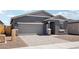 Charming home features a two-car garage, stone veneer accents, and a paved driveway, blending style and functionality at 18256 W La Senda Dr, Surprise, AZ 85387