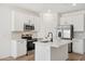 Well-lit kitchen boasts white cabinets, a kitchen island, and stainless steel appliances at 18256 W La Senda Dr, Surprise, AZ 85387