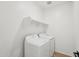 Well-lit laundry room includes a modern washer, dryer, and a shelf for storage at 18256 W La Senda Dr, Surprise, AZ 85387