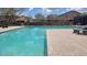 Community pool with ample seating, well maintained with beautiful landscaping on a sunny day at 18261 W Camino De Oro --, Surprise, AZ 85387