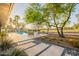 Expansive backyard featuring a swimming pool, lush greenery, patio seating, and mature trees at 20 W Canterbury Ln, Phoenix, AZ 85023