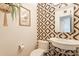 Stylish powder room featuring unique wallpaper, pedestal sink, and chic decor at 20 W Canterbury Ln, Phoenix, AZ 85023