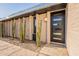 Modern entryway featuring a sleek black door, desert landscaping, and a stylish exterior lighting at 20 W Canterbury Ln, Phoenix, AZ 85023