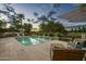 Relaxing outdoor oasis with a pool with a waterfall feature, baja shelf seating, and comfortable patio furniture at 20 W Canterbury Ln, Phoenix, AZ 85023