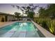 Inviting pool featuring baja shelf loungers, waterfall feature, and lush landscaping, ideal for relaxing and entertaining at 20 W Canterbury Ln, Phoenix, AZ 85023