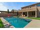 An expansive backyard features a swimming pool, lounge seating, an outdoor dining area, and lush landscaping at 20483 E Mockingbird Dr, Queen Creek, AZ 85142