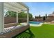 Backyard featuring a pool, covered pergola, manicured landscaping, and artificial turf at 20483 E Mockingbird Dr, Queen Creek, AZ 85142
