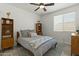 Cozy bedroom boasts a queen bed, stylish furnishings, a ceiling fan, and a bright window at 20483 E Mockingbird Dr, Queen Creek, AZ 85142