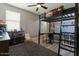 Fun bedroom features a lofted bed with desk, storage, a ceiling fan, and a large window at 20483 E Mockingbird Dr, Queen Creek, AZ 85142
