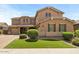 Charming two-story home with a well-manicured lawn, mature trees, and a three-car garage and a beautiful architectural style at 20483 E Mockingbird Dr, Queen Creek, AZ 85142