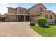 A charming two-story home featuring a three-car garage, manicured landscaping, and a paved driveway at 20483 E Mockingbird Dr, Queen Creek, AZ 85142
