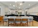 A modern, open-concept kitchen with a dining table, white cabinets, stainless steel appliances, and an island with pendant lighting at 20483 E Mockingbird Dr, Queen Creek, AZ 85142