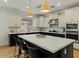An open kitchen features an island with bar seating, pendant lighting, stainless appliances, and two-tone cabinets at 20483 E Mockingbird Dr, Queen Creek, AZ 85142