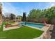 Backyard featuring a pool, lounge chairs, a shade umbrella, and a covered seating area at 20483 E Mockingbird Dr, Queen Creek, AZ 85142