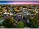 Stunning aerial view of a suburban neighborhood with lush green trees, sparkling pools, and well-maintained homes at sunset at 2066 E Lockwood St, Mesa, AZ 85213