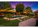 Night time view of the backyard with a pool, patio furniture, palm trees and a hammock at 2066 E Lockwood St, Mesa, AZ 85213