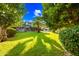 Expansive backyard features a lush lawn, mature trees, inviting pool, and a covered patio perfect for relaxation and entertaining at 2066 E Lockwood St, Mesa, AZ 85213
