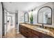 Elegant bathroom featuring double sinks with granite counters, dark wood cabinetry, and decorative arched mirrors at 2066 E Lockwood St, Mesa, AZ 85213